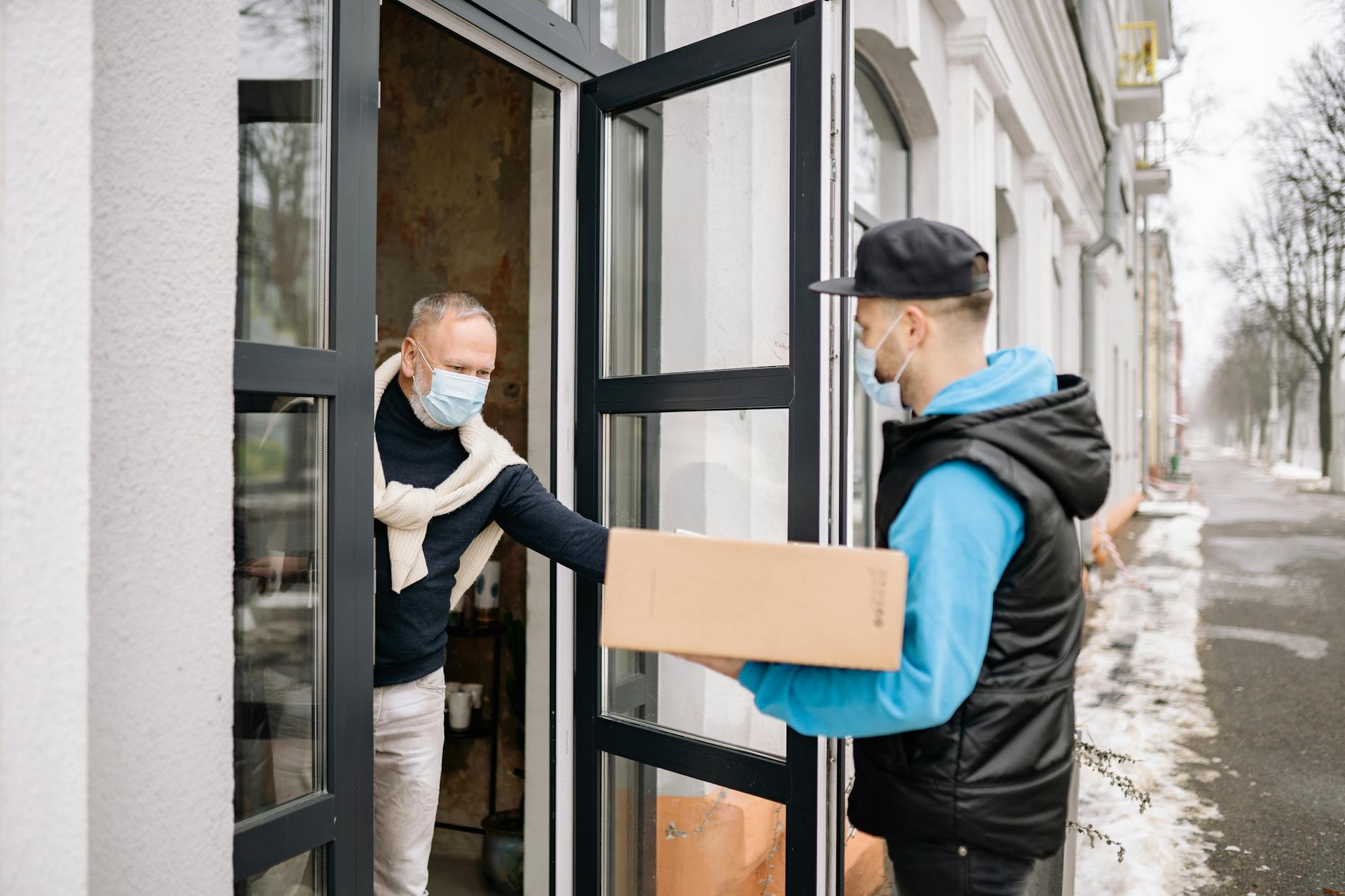 Apothekenlieferung wird an einen Senioren im Apartment übergeben