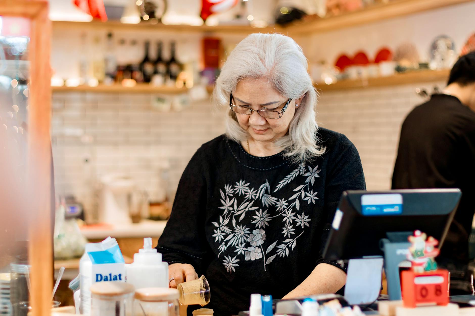 Seniorin sitzt in einem Café im Stadtteil und unterhält sich mit anderen Gästen