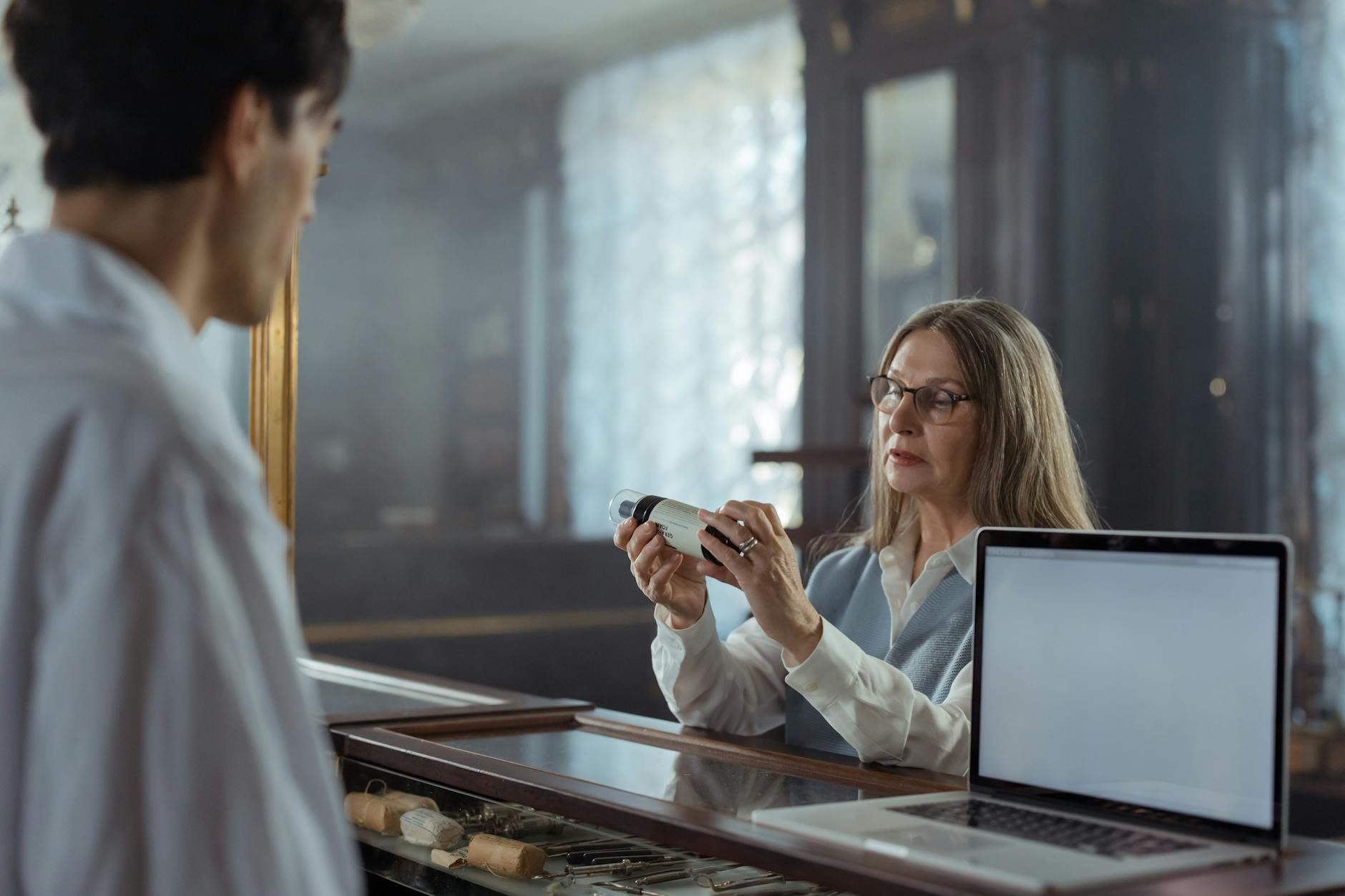 Apothekerin und Pflegekraft besprechen die Medikamentenversorgung eines Bewohners