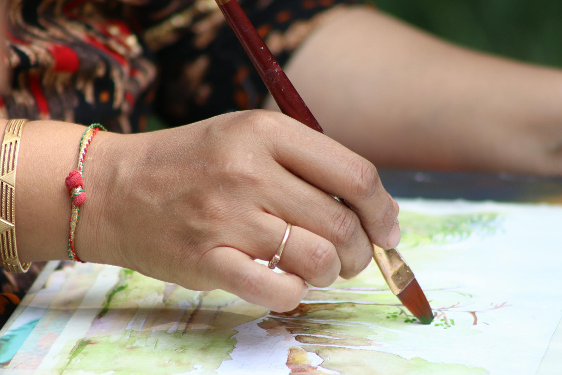 Seniorin malt im Mal-Atelier einer Seniorenresidenz mit Aquarellfarben