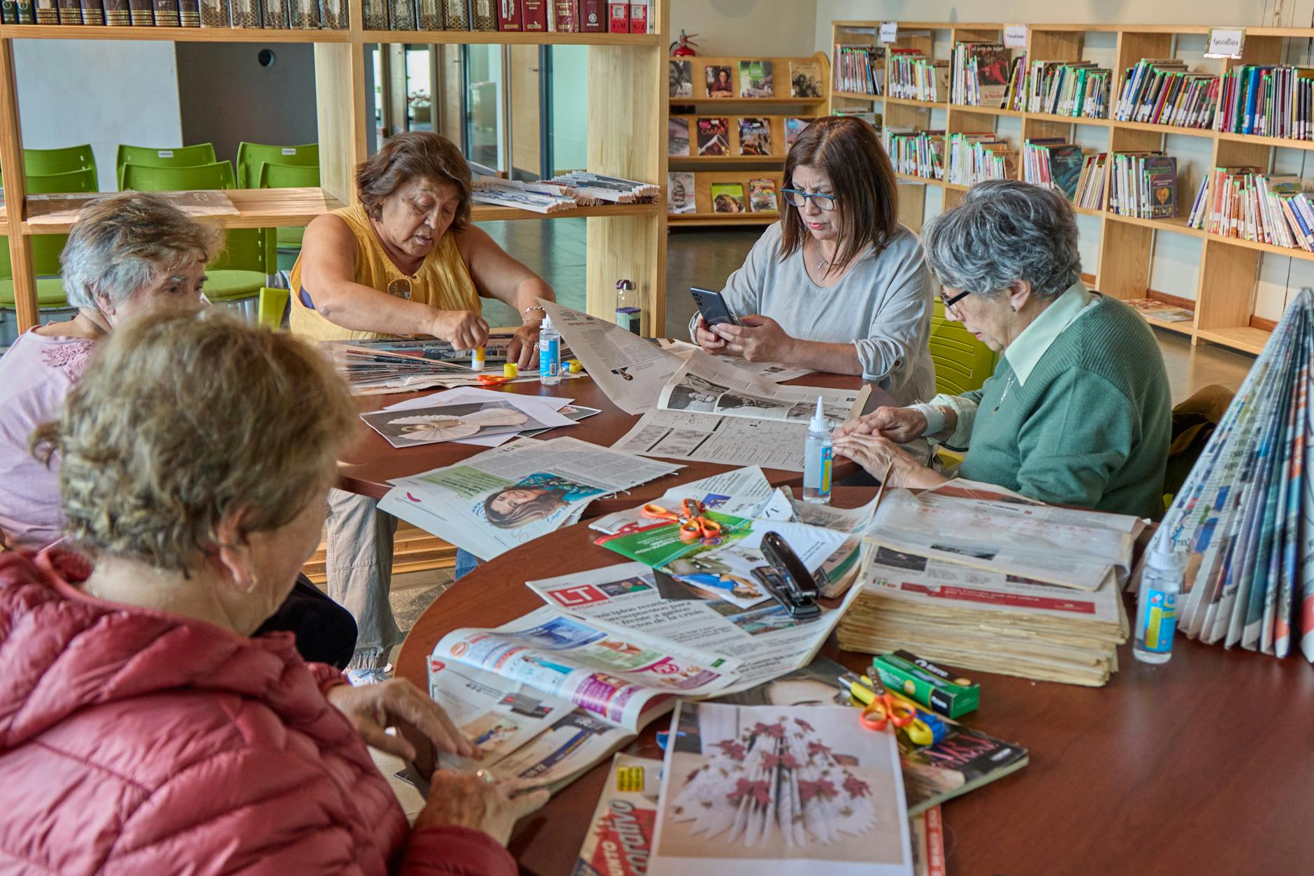 Buchclub-Treffen mehrerer Seniorinnen und Senioren in der Bibliothek einer Residenz