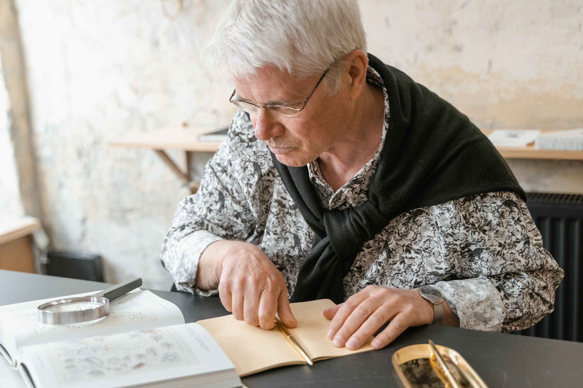 Ältere Frau schreibt mit Stift in ein Buch