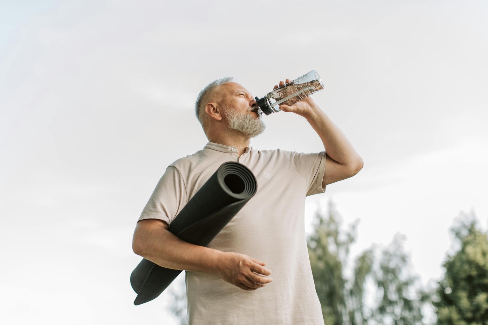 Ältere Frau trinkt an einem heißen Sommertag ein Glas Wasser